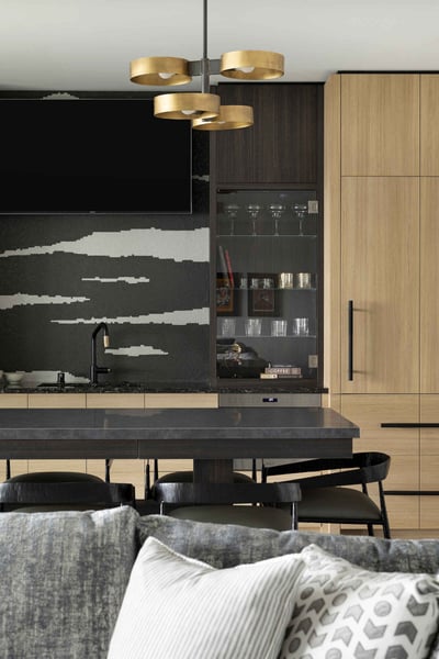 Modern kitchen with a dark island, glass display cabinetry, and wood tones by MA Peterson, Twin Cities
