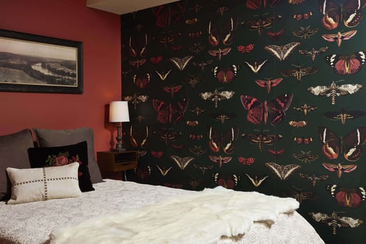 Bedroom with butterfly-themed wallpaper and red walls, designed by MA Peterson in Twin City