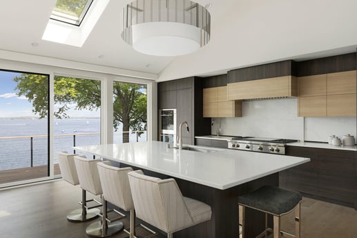 Contemporary kitchen with floor-to-ceiling windows and a view of the lake, designed by MA Peterson in the Twin Cities