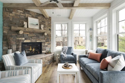 Bright and comfortable sunroom with a stone fireplace, remodeled by MA Peterson in the Twin Cities