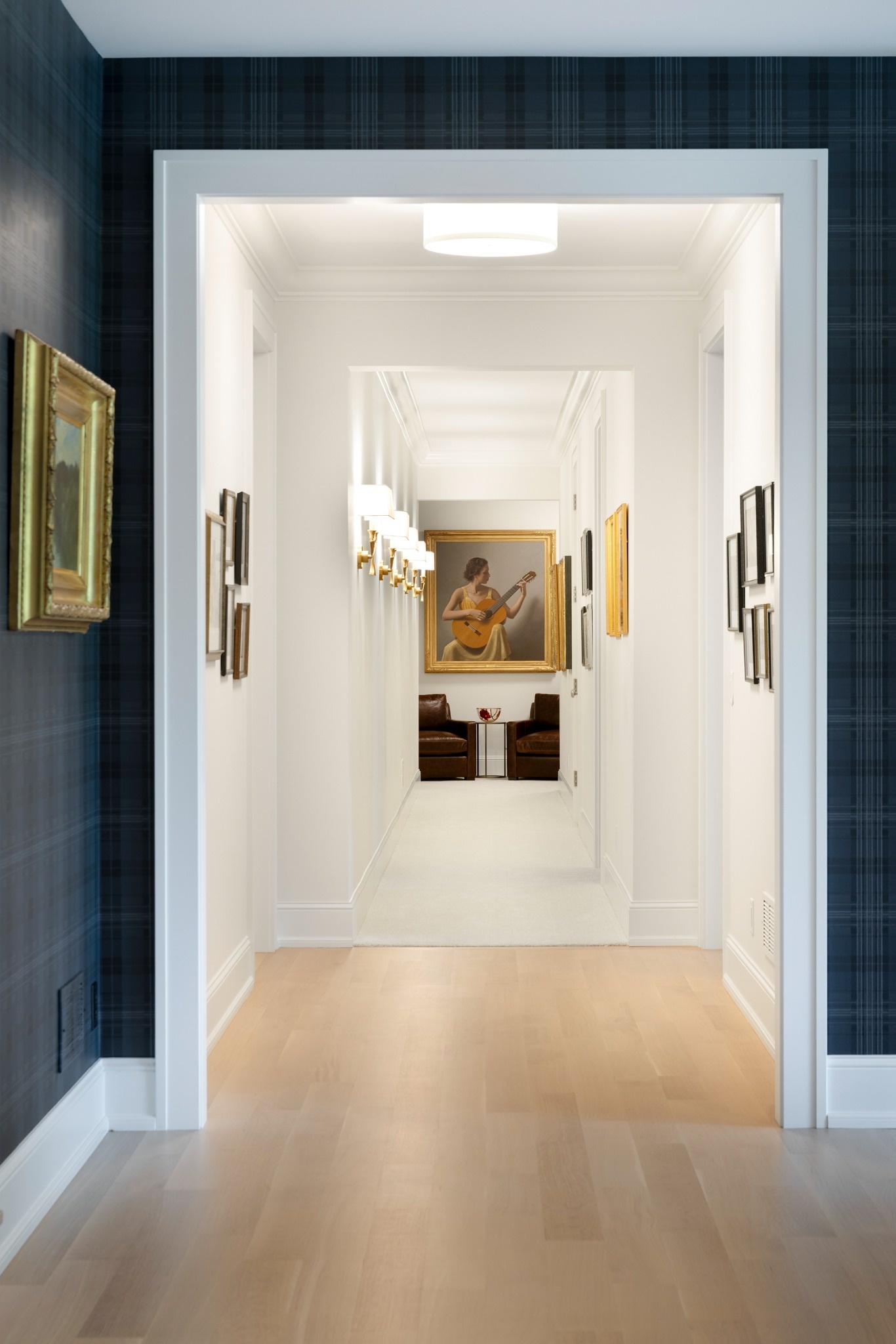 custom home hallway with plaid wallpaper and gallery art in wayzata mn
