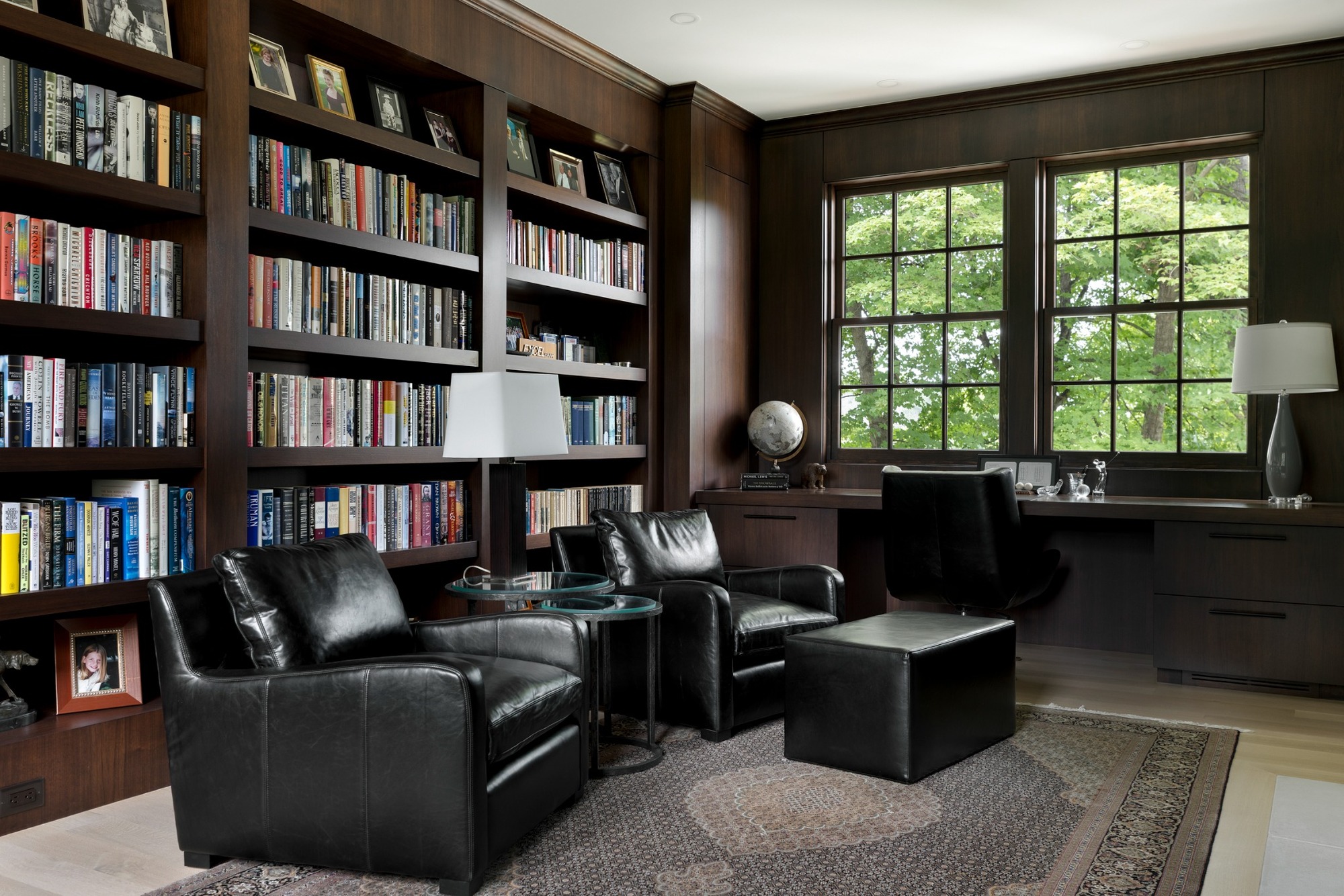 custom home library with dark wood bookshelves and leather seating in wayzata mn