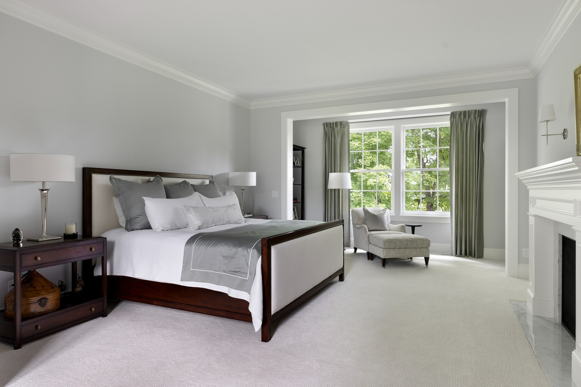 custom home primary bedroom with fireplace and window sitting area in wayzata mn