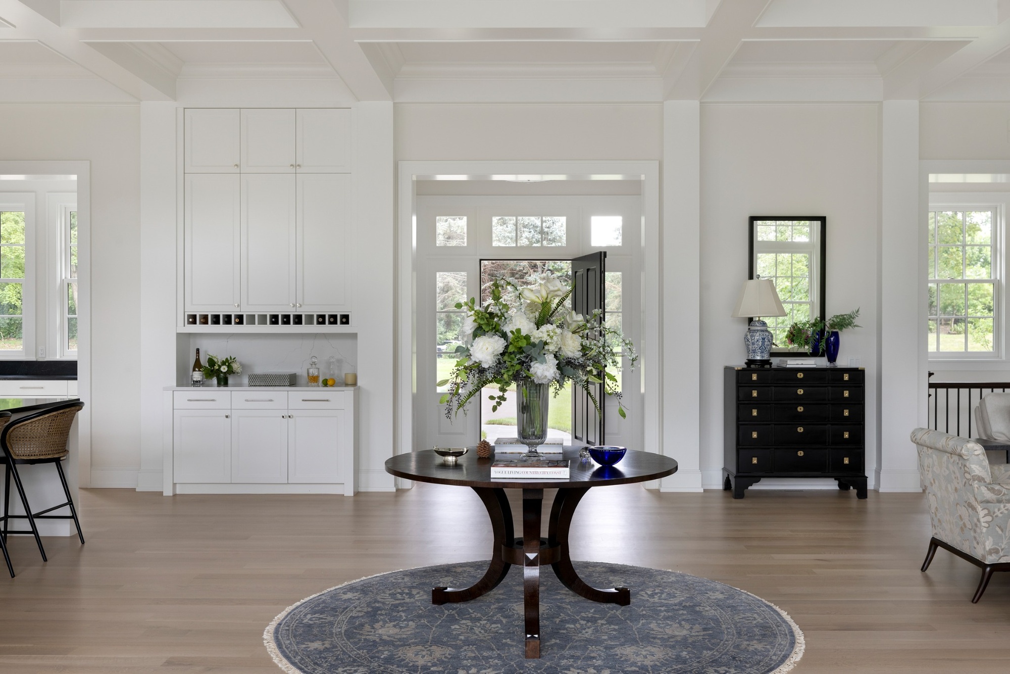 open foyer with round table floral arrangement and built in bar in custom home in wayzata mn