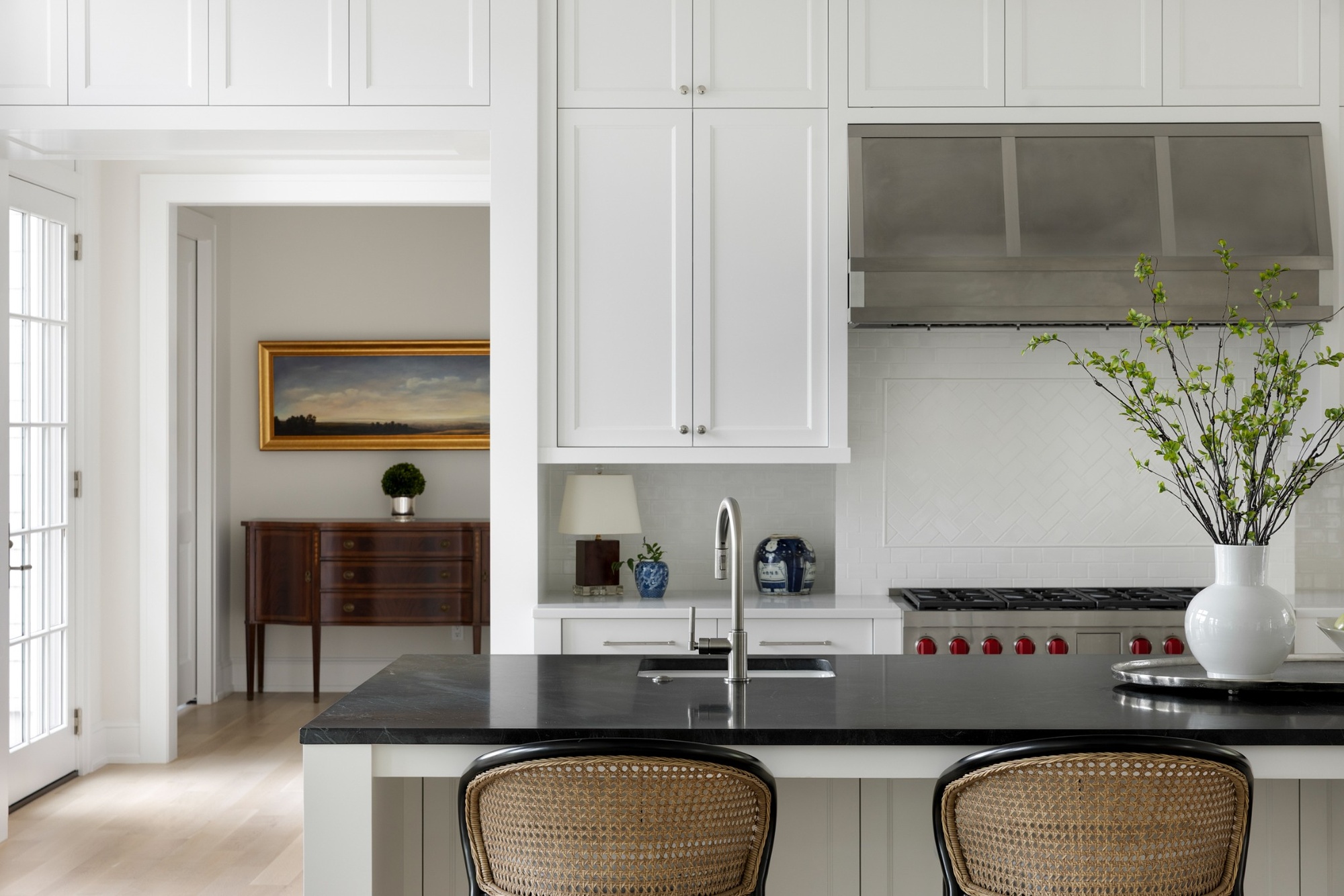 wayzata mn custom home kitchen with black island white cabinetry and stainless range hood