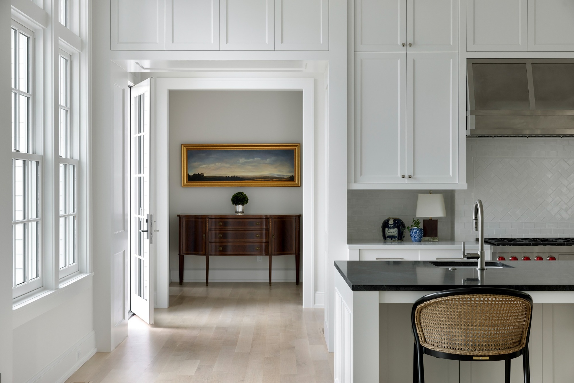 wayzata mn custom home kitchen with white cabinetry black island and adjacent entry hall