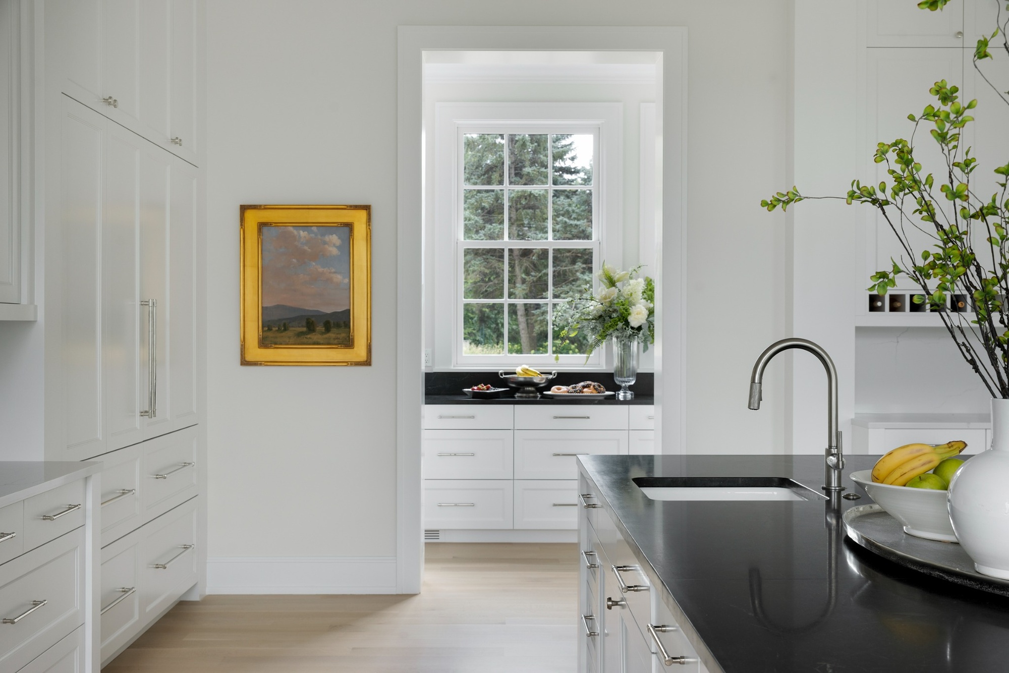 wayzata mn custom home kitchen with white cabinetry black island and windowed pantry