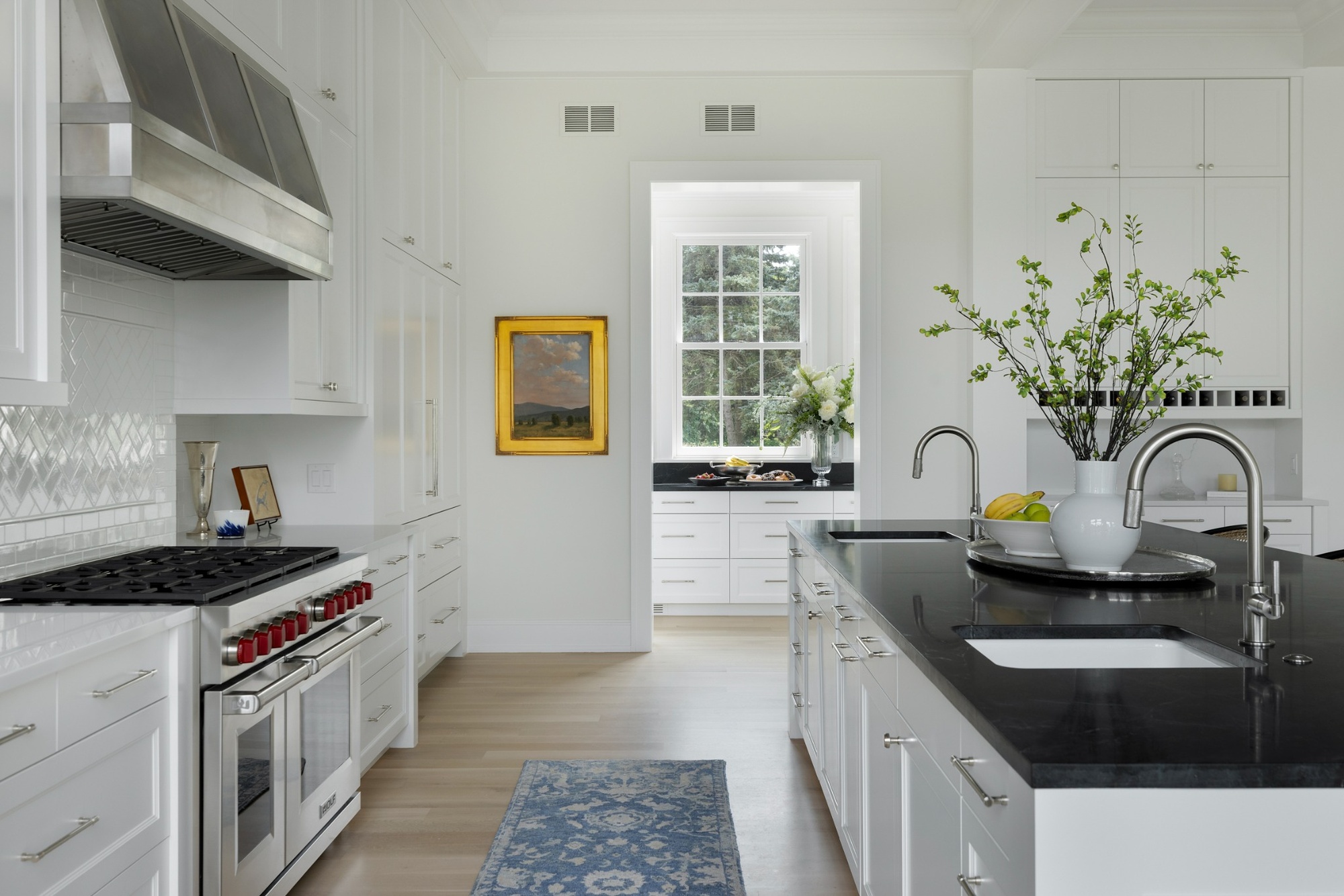 wayzata mn custom home kitchen with white cabinets black island double sinks and range