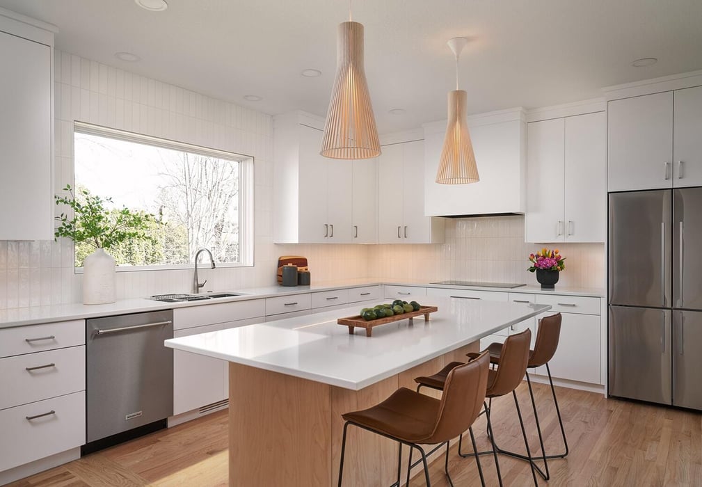 Contemporary kitchen with island seating and window view in Crafting Warmth in Modern home by MA Peterson