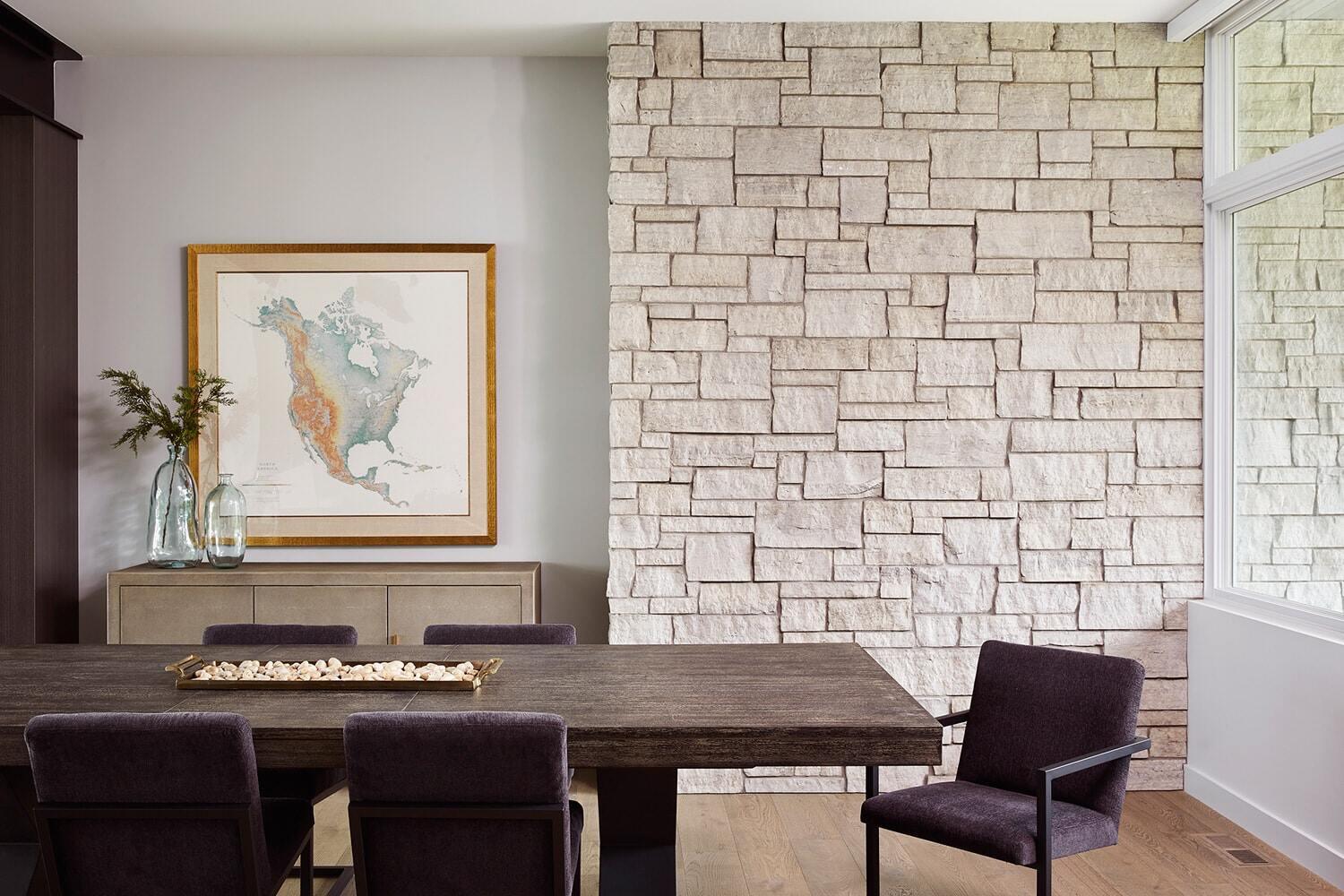 Contemporary dining area with stone accent wall and natural decor, MA Peterson, Twin Cities