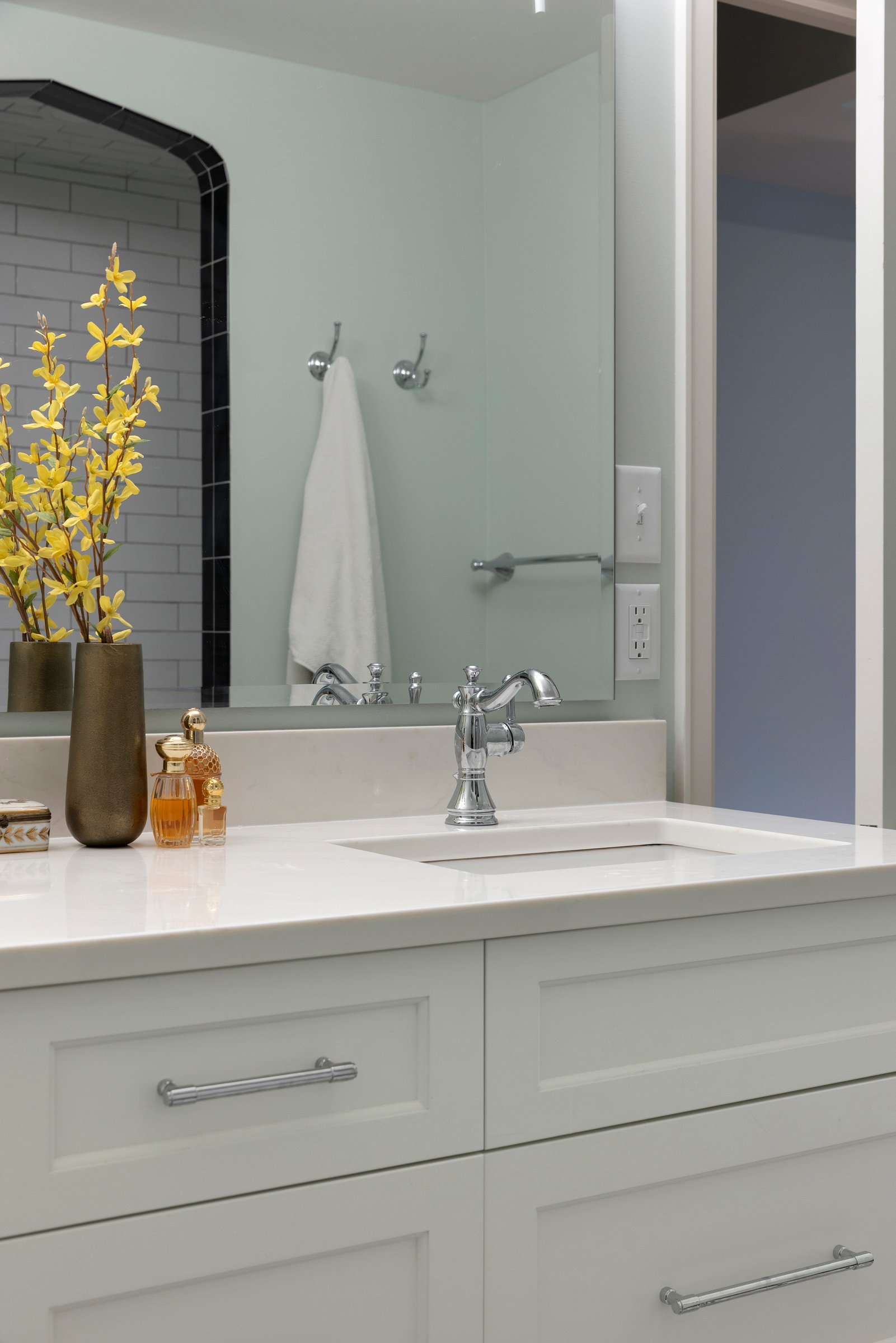 Bathroom vanity with custom cabinetry, stone countertop, and integrated storage