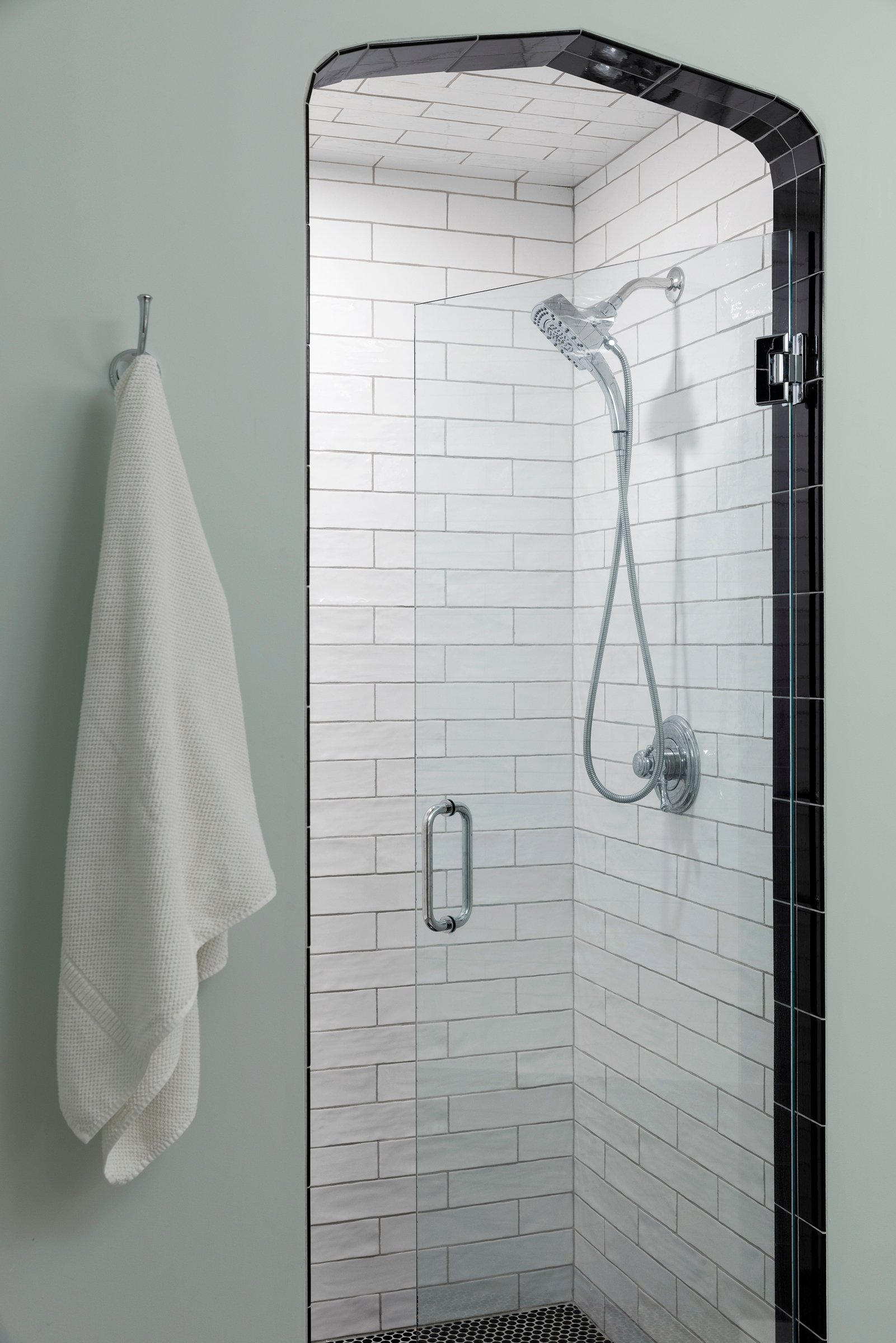 Walk-in shower with floor-to-ceiling tile, built-in niche, and brushed metal fixtures