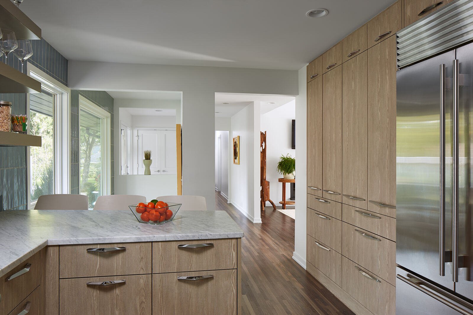 Sleek kitchen design with wooden cabinetry and marble countertops in a custom home by MA Peterson, Twin City