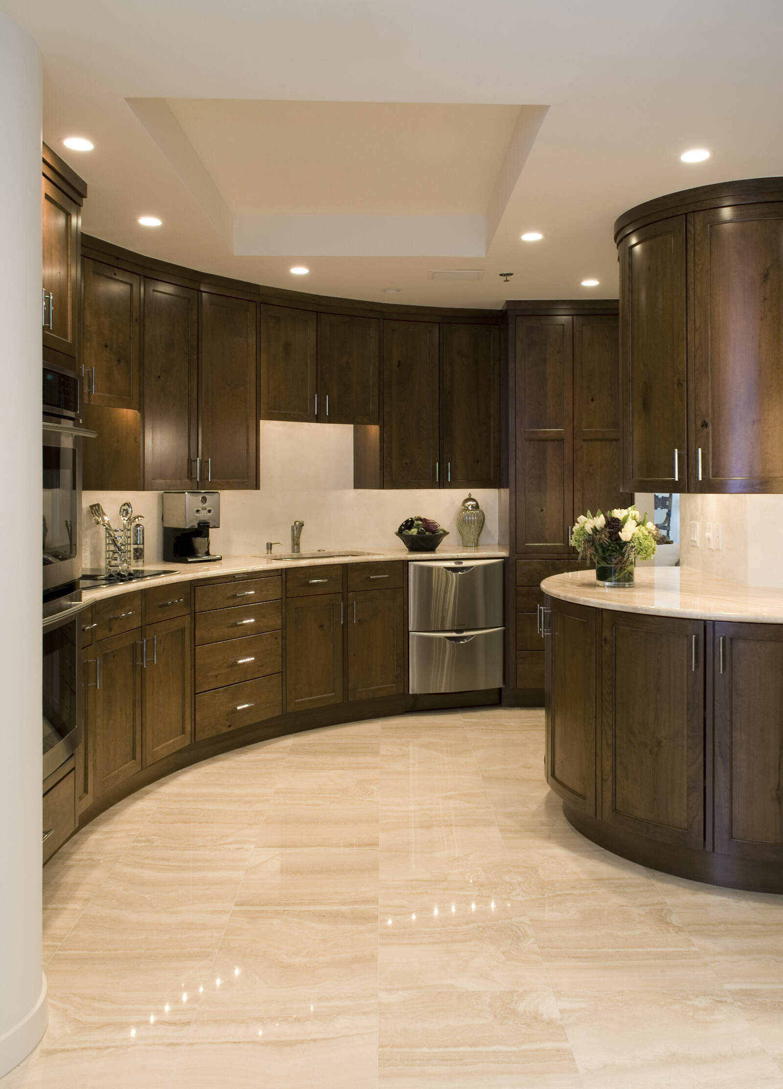 Spacious kitchen with curved wooden cabinets and marble flooring in a custom home by MA Peterson, Twin City