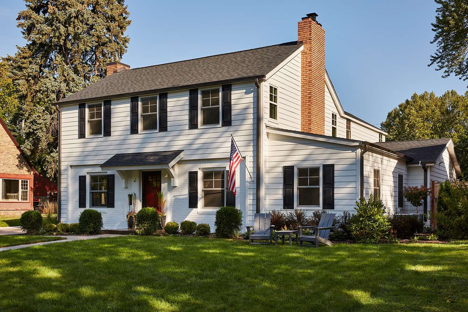 Exterior view of a classic white house with American flag in Twin Cities, remodeled by MA Peterson