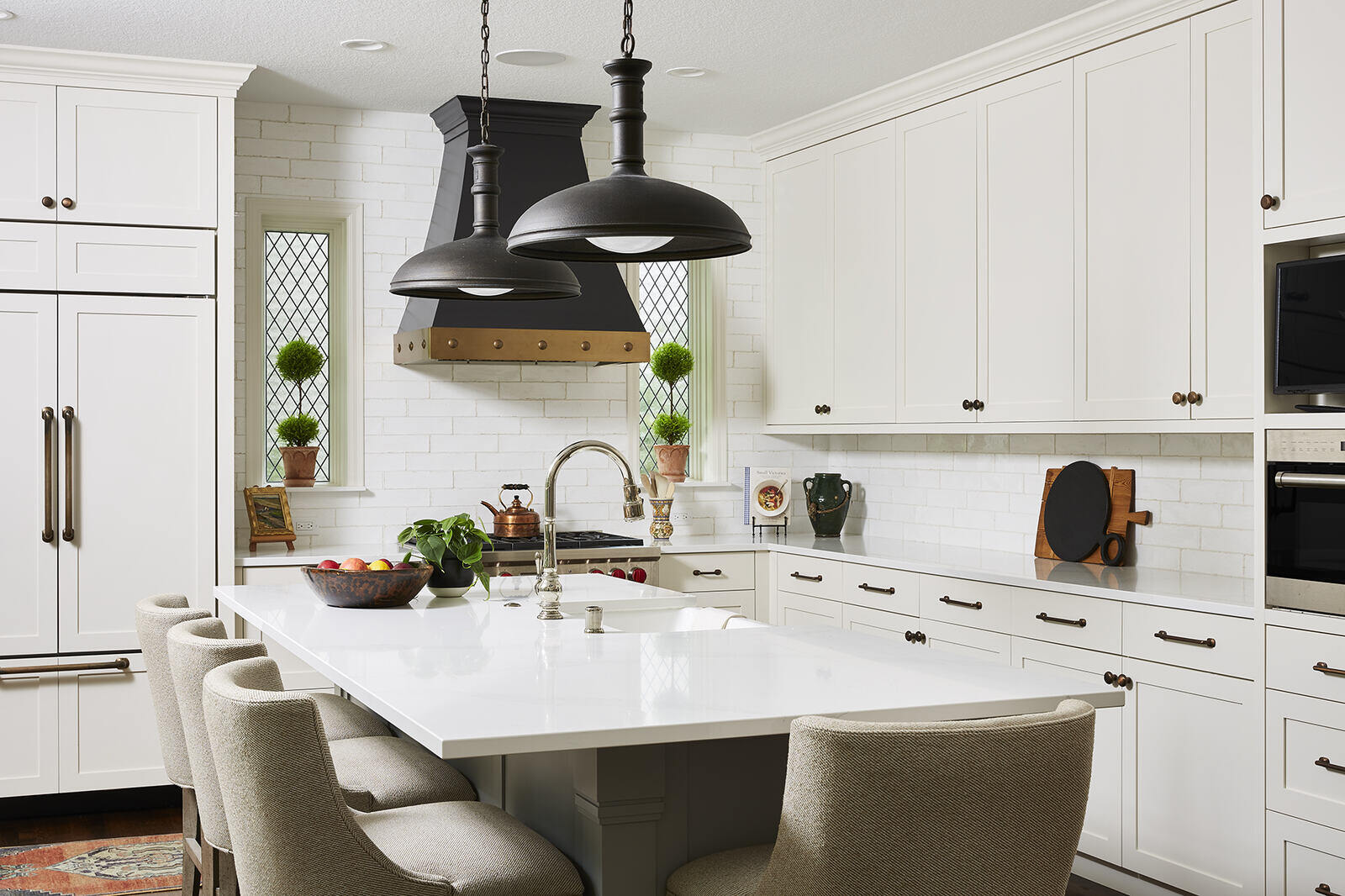 Classic kitchen with white cabinets and black pendant lights in a Twin Cities remodel by MA Peterson