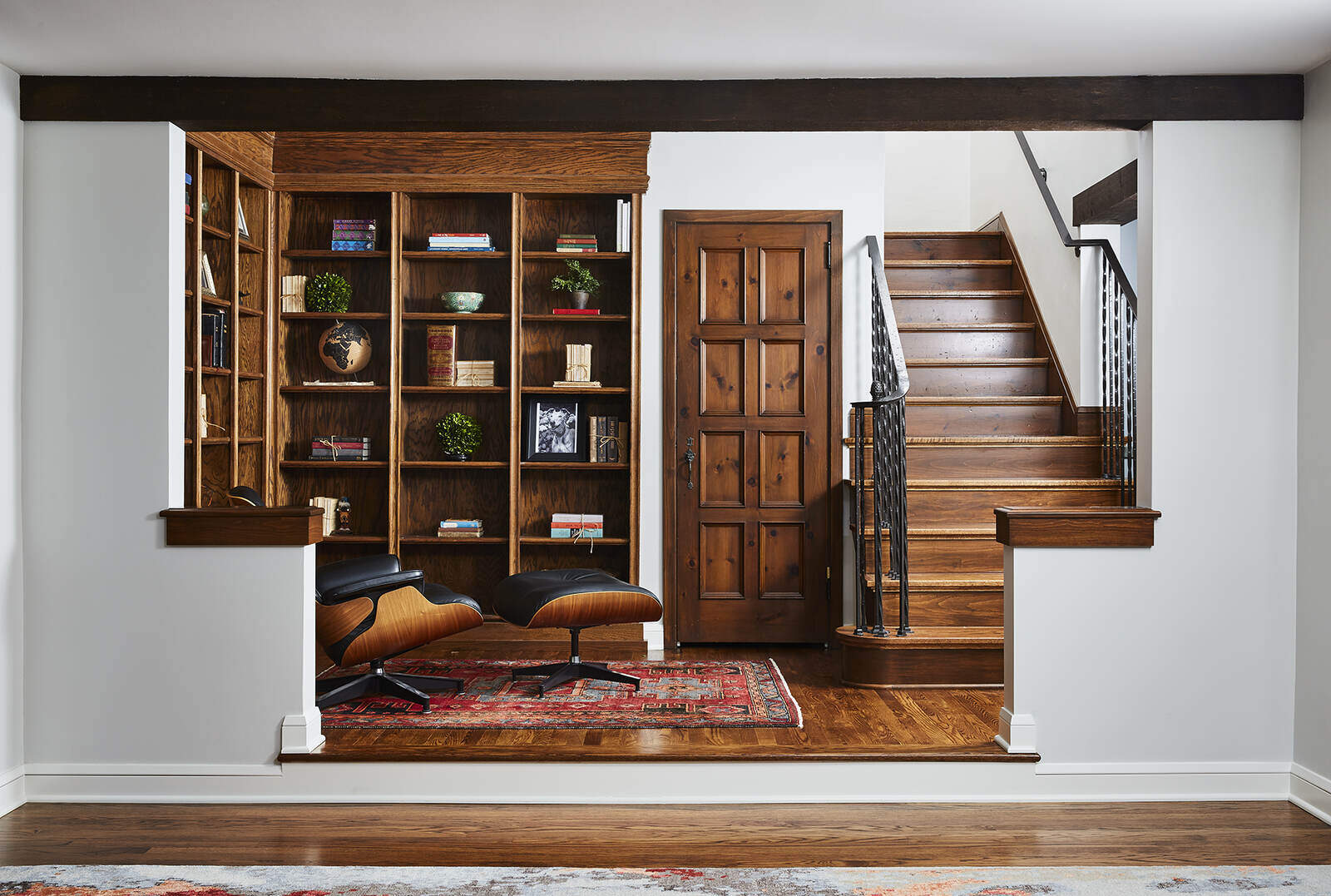 Cozy reading nook with built-in bookshelves and wooden staircase in a Twin Cities remodel by MA Peterson